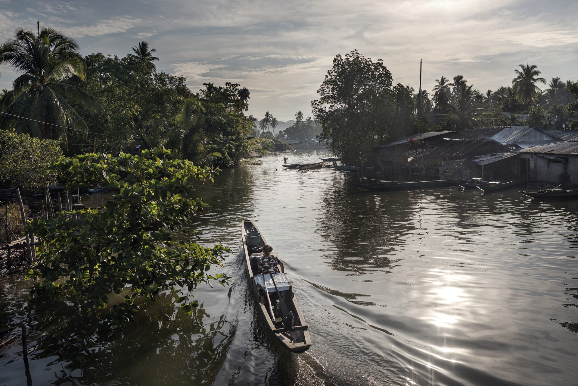 A small boat carrying two people sailing towards Kabasalan.